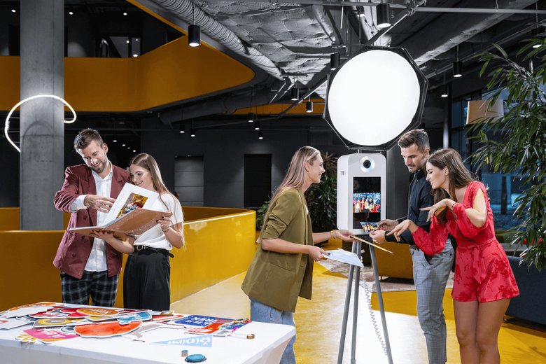 Lidé si prohlíží fotoknihu u stolu s rekvizitami